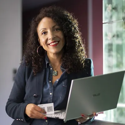 Myriam Lepel, fondatrice et directrice de Strelitzia, souriante avec son ordinateur portable